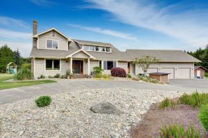 Large beige house with white trim, and well kept lawn